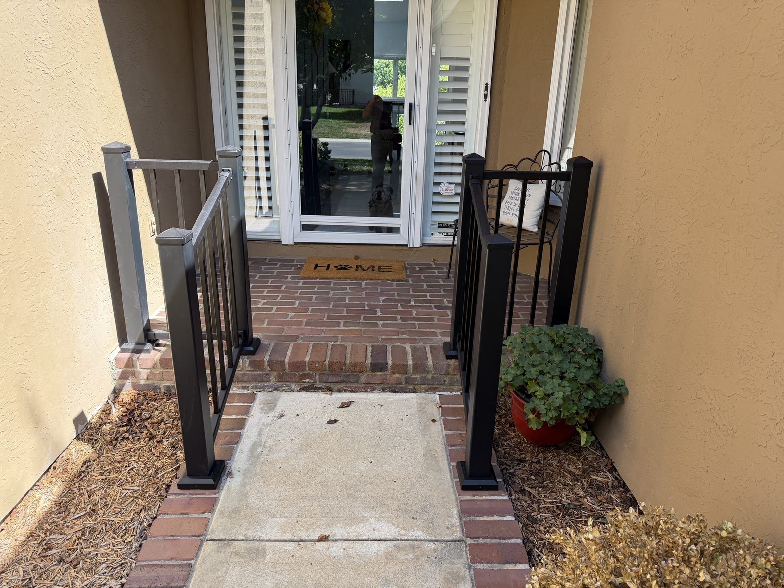 Matching black handrails framing a brick front entry